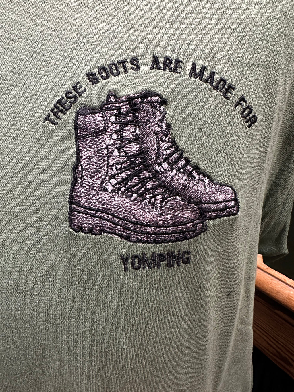 Green shirt with embroidered boots and text 'These boots are made for yomping' 
