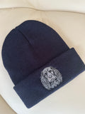 Navy blue beanie with a embroidered design on a beige surface