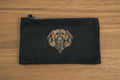 Black pouch with embroidered dog design on a wooden surface
