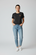 Person wearing a black t-shirt with a spaniel logo and light blue jeans on a white background