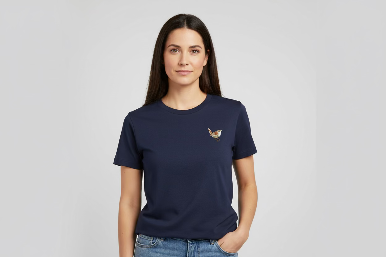 Woman wearing a navy blue t-shirt with a small logo on a light gray background