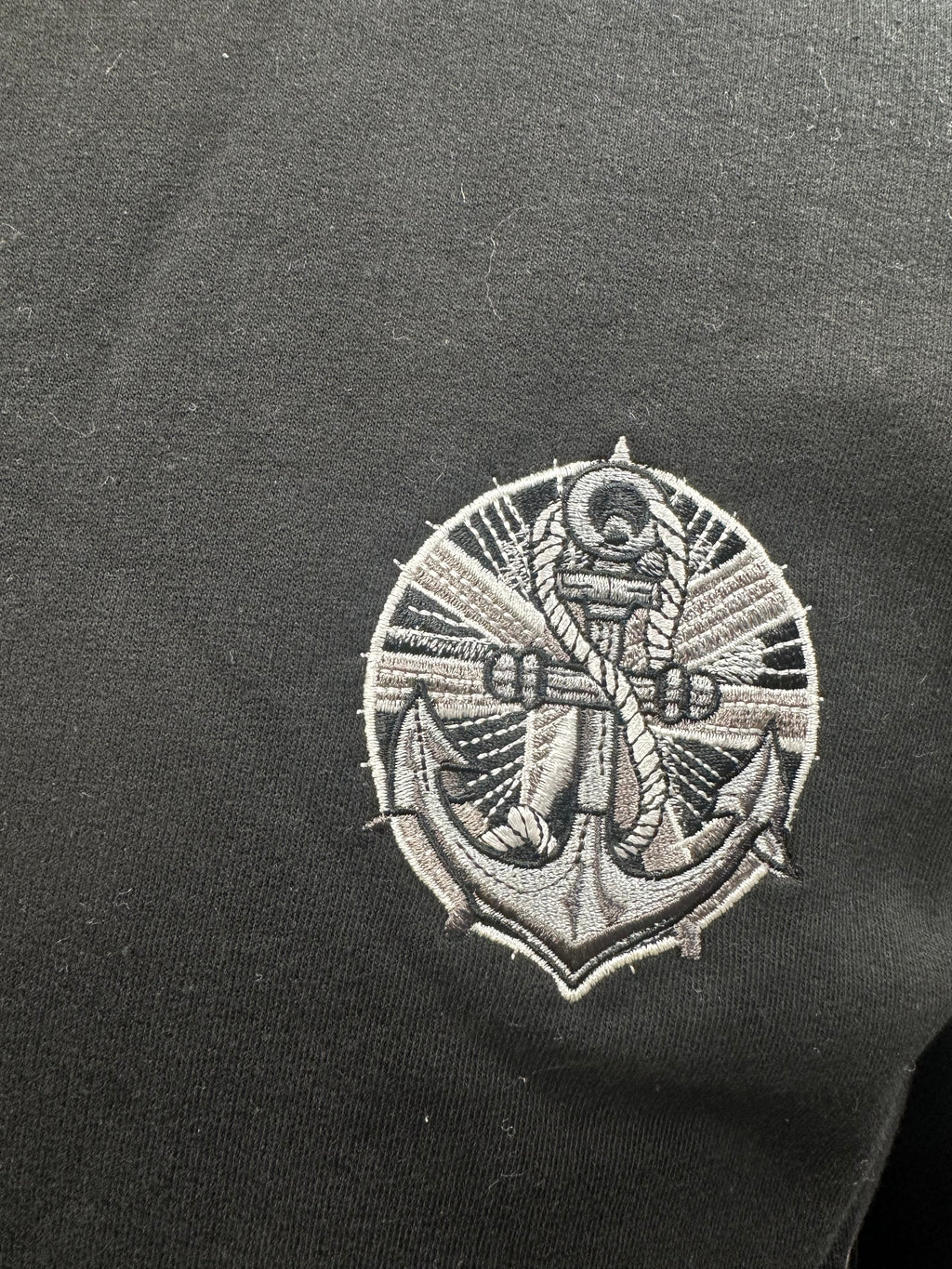 Embroidered anchor design on a black sweatshirt